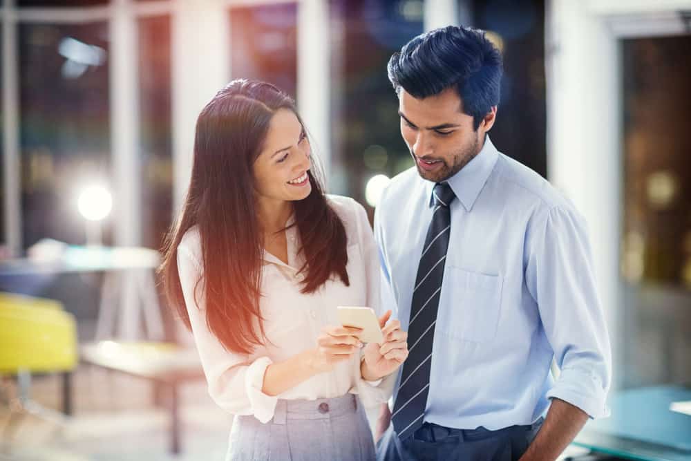 une femme montre quelque chose au téléphone à un homme