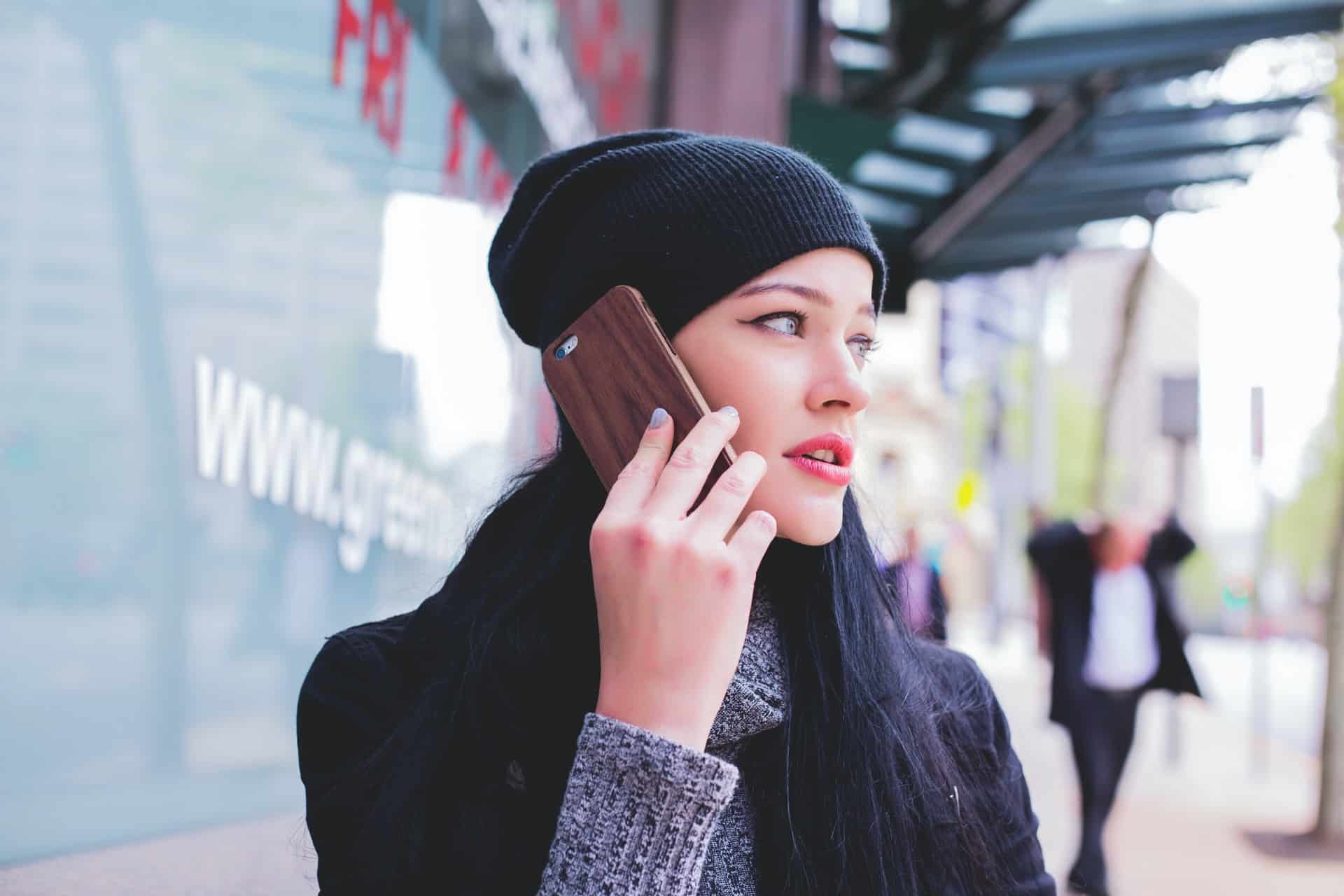 une femme parle au téléphone alors qu'elle marche dans la rue