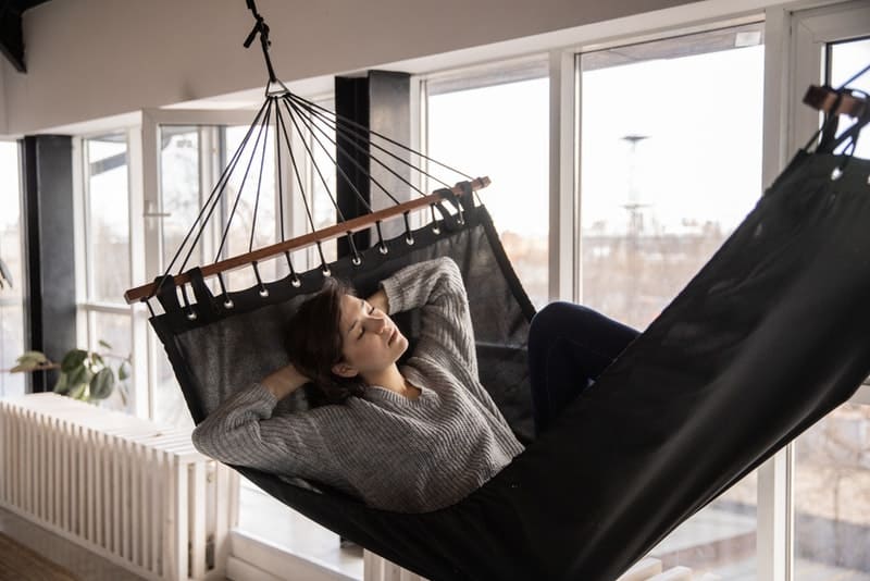 une femme se reposant dans une balançoire dans un appartement