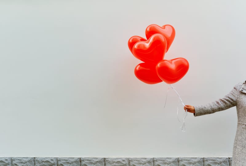 une femme tenant un ballon en forme de coeur