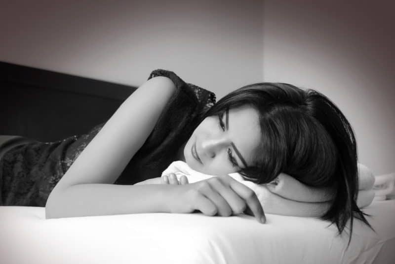 une femme triste allongée sur le lit