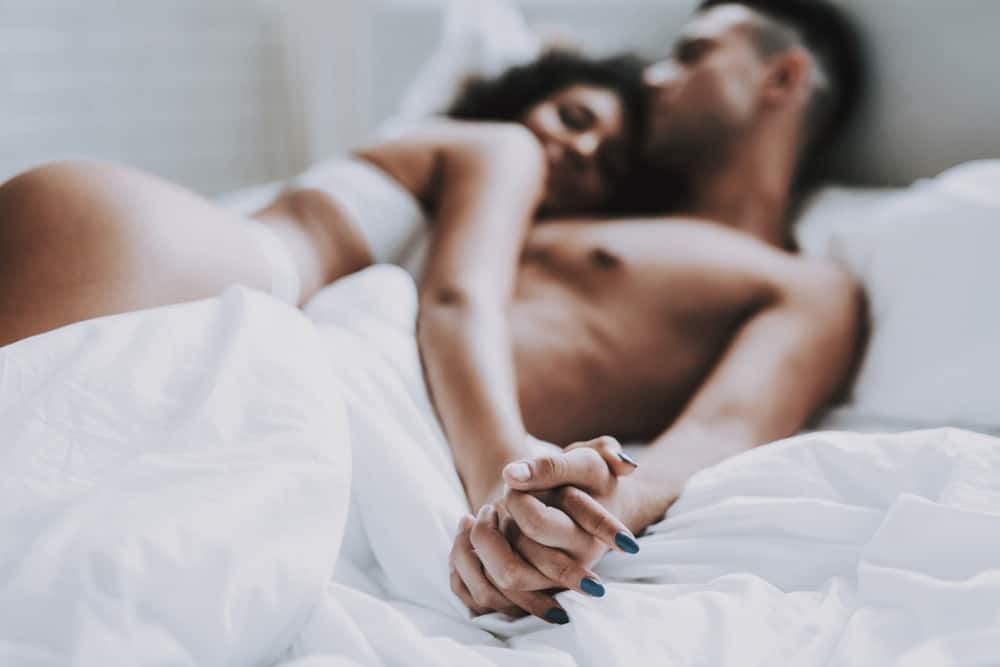 une femme à moitié nue se trouve sur un homme