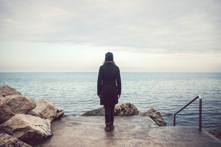 femme solitaire debout au bord de la mer