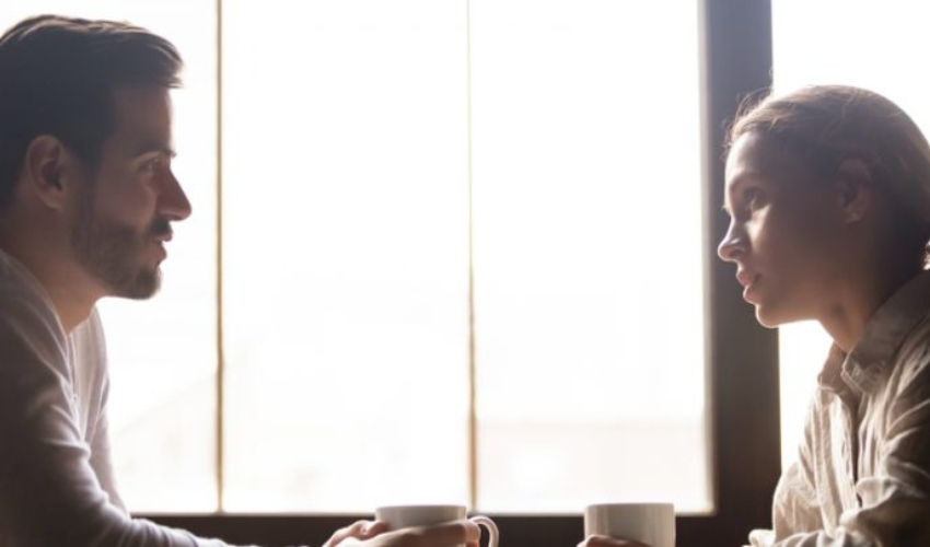 un homme et une femme parlent a table