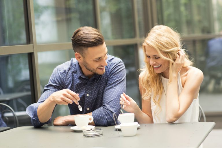 un homme et une femme s'assoient à une table et parlent