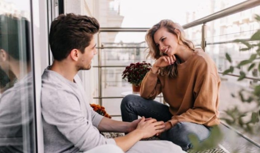 un homme et une femme sassoient sur la terrasse et parlent