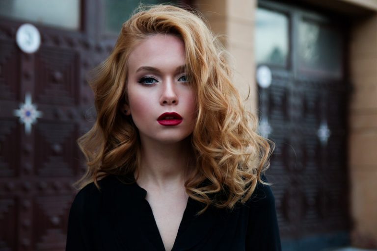 une femme aux cheveux blonds avec un chapeau sur la tête