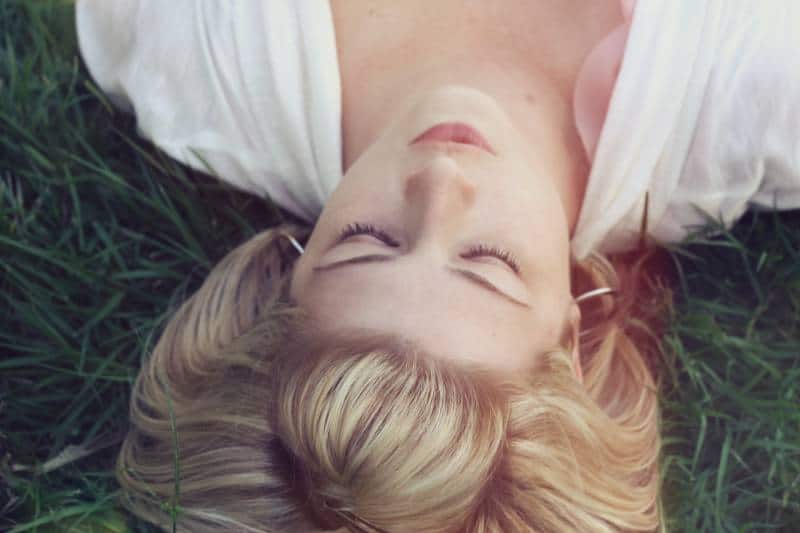 Femme allongée sur des herbes vertes