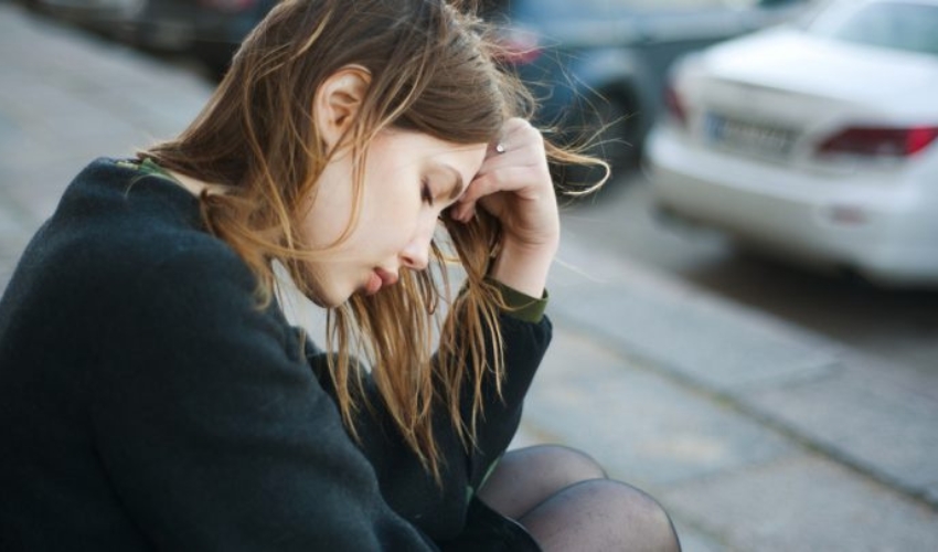 une femme triste est assise sur les escaliers