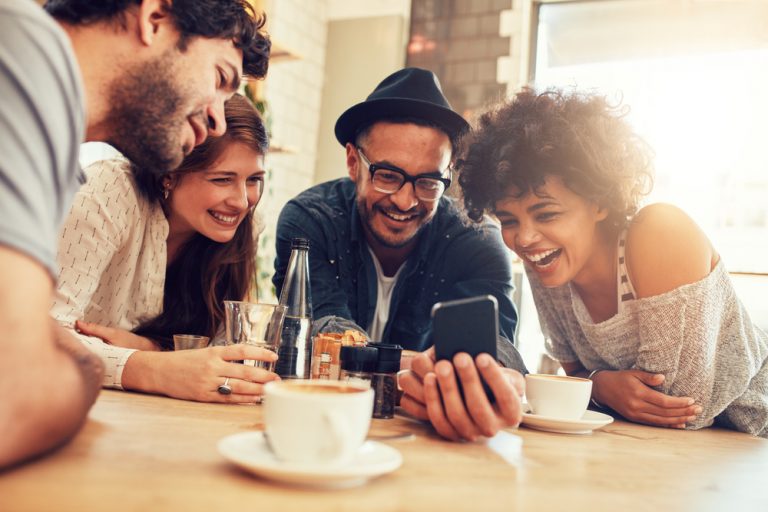 les amis regardent le téléphone et rient