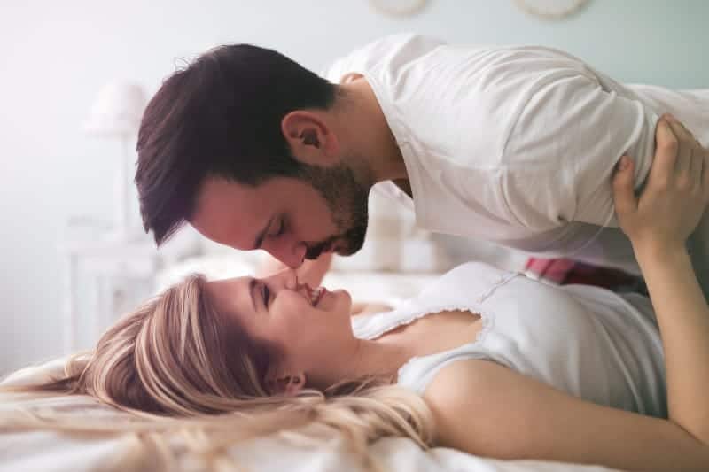 Un beau couple s'embrasse au lit