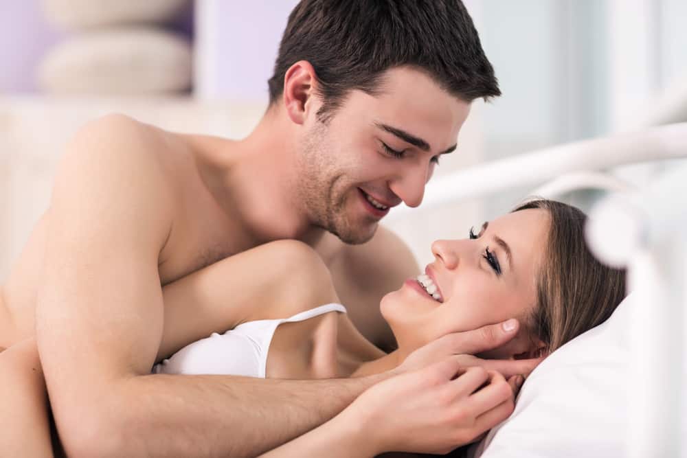 Un beau jeune couple amoureux allongé dans son lit