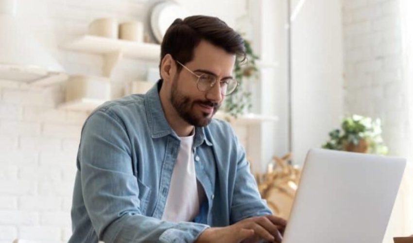 un homme est assis a une table et une cle sur un ordinateur portable