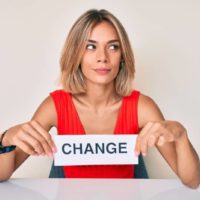 Belle femme tenant la bannière de changement souriant regardant sur le côté