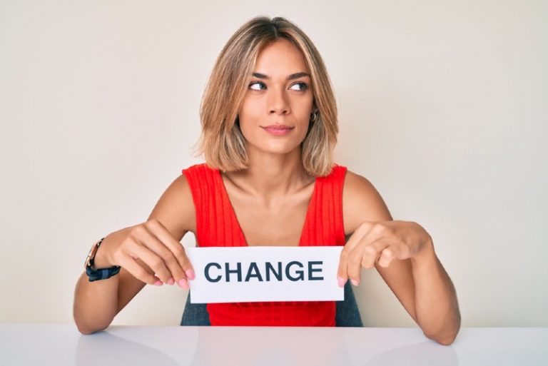 Belle femme tenant la bannière de changement souriant regardant sur le côté
