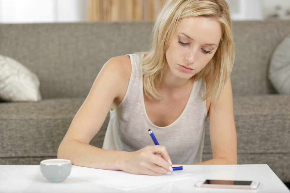femme à la maison écrivant sur le papier
