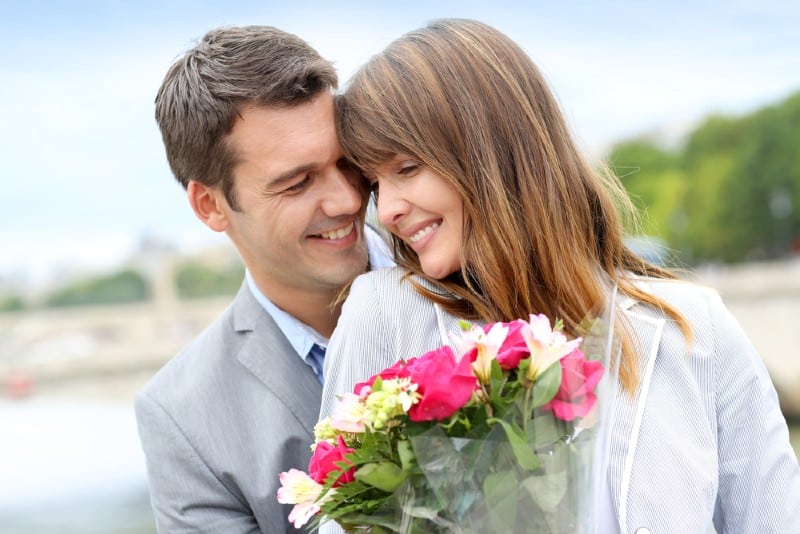 Portrait d'homme romantique donnant des fleurs à la femme