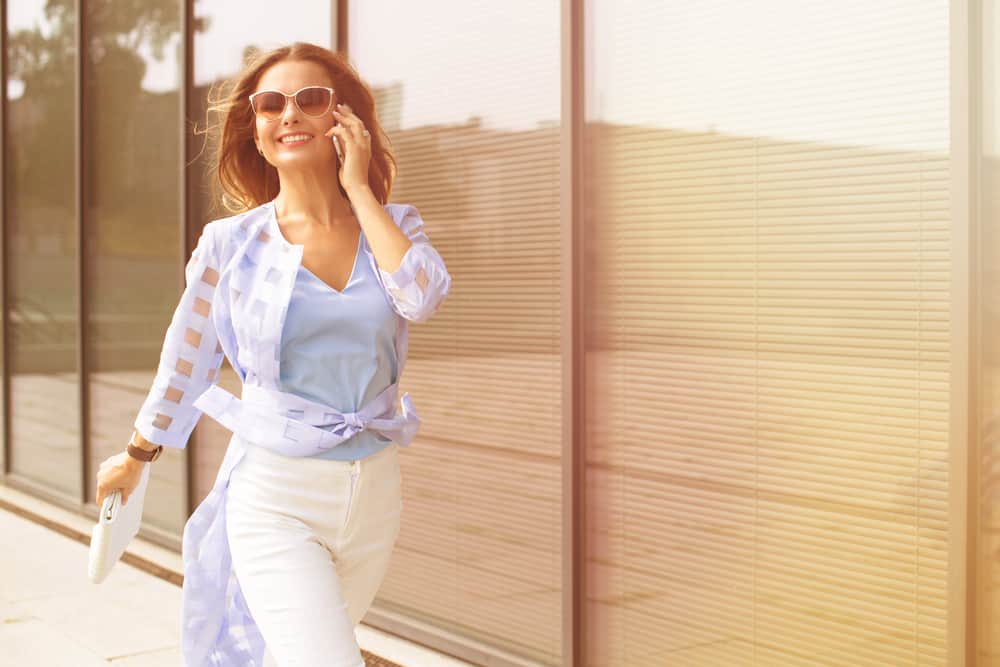 la femme pose ses lunettes tout en parlant au téléphone