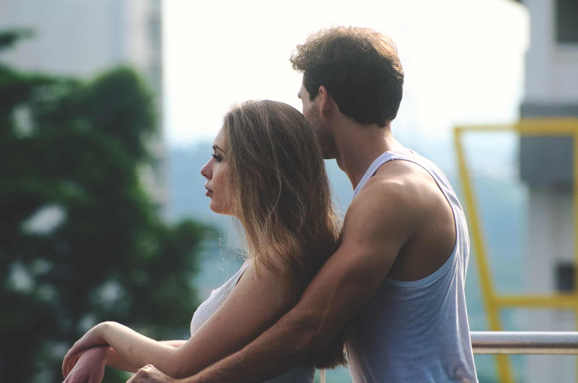 l'homme debout derrière la femme la serra dans ses bras
