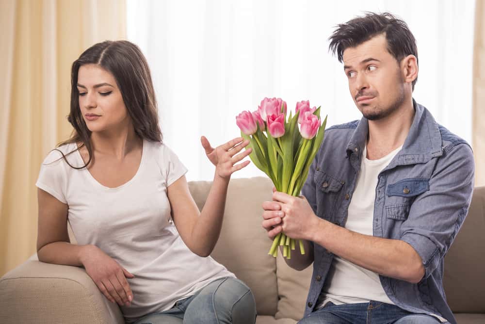un homme a acheté à une femme un bouquet de fleurs qu'elle l'ignore