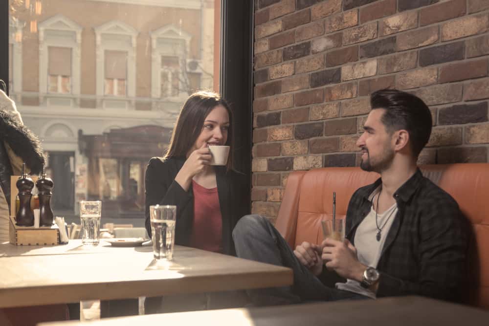 un homme et une femme buvant du café et parlant