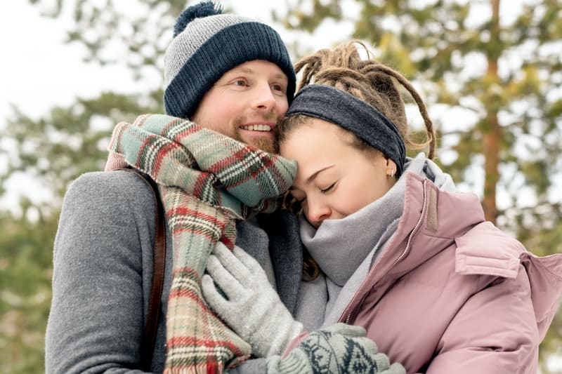un homme et une femme embrassant dans des vestes d'hiver