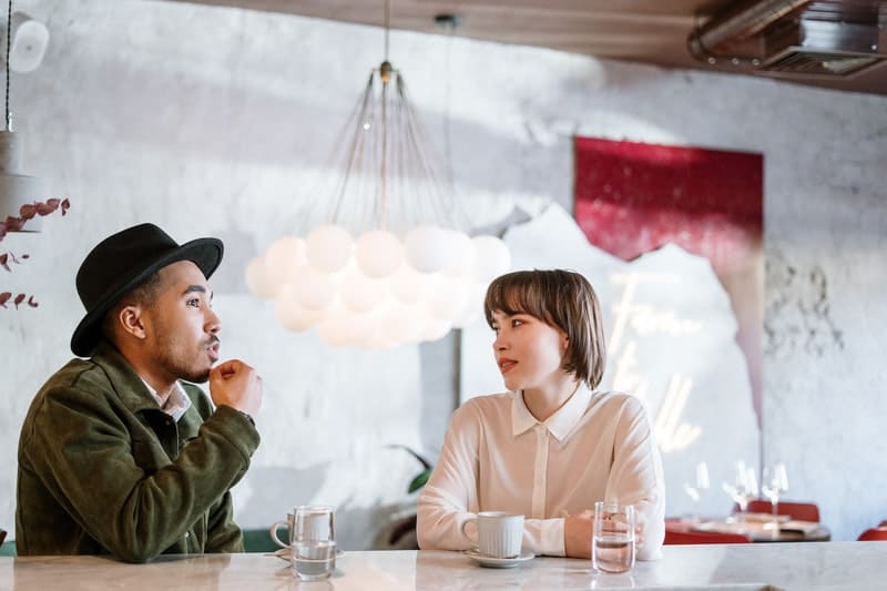 un homme et une femme parlant autour du café