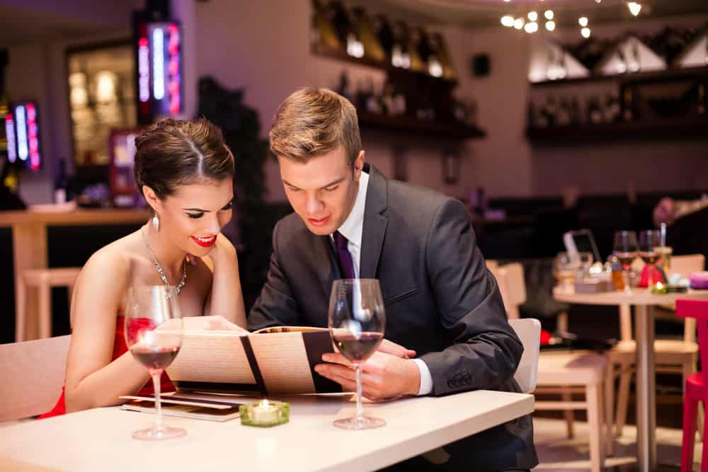 un homme et une femme regardent le menu