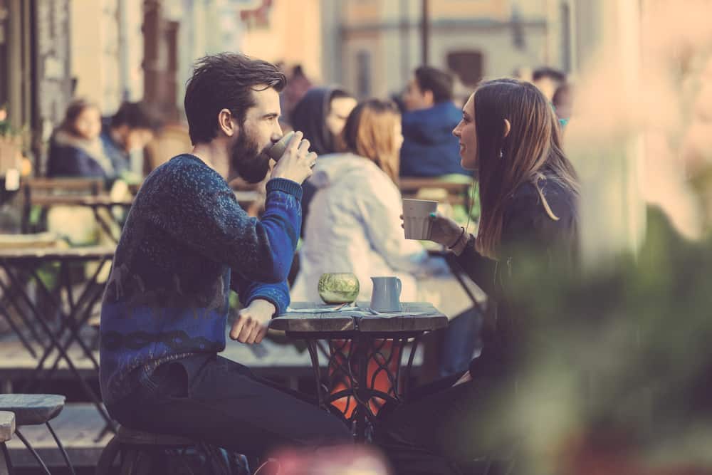 un homme et une femme s'assoient et boivent du café
