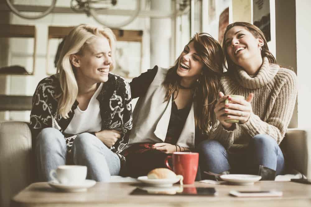 une femme avec des amis assis et buvant du café