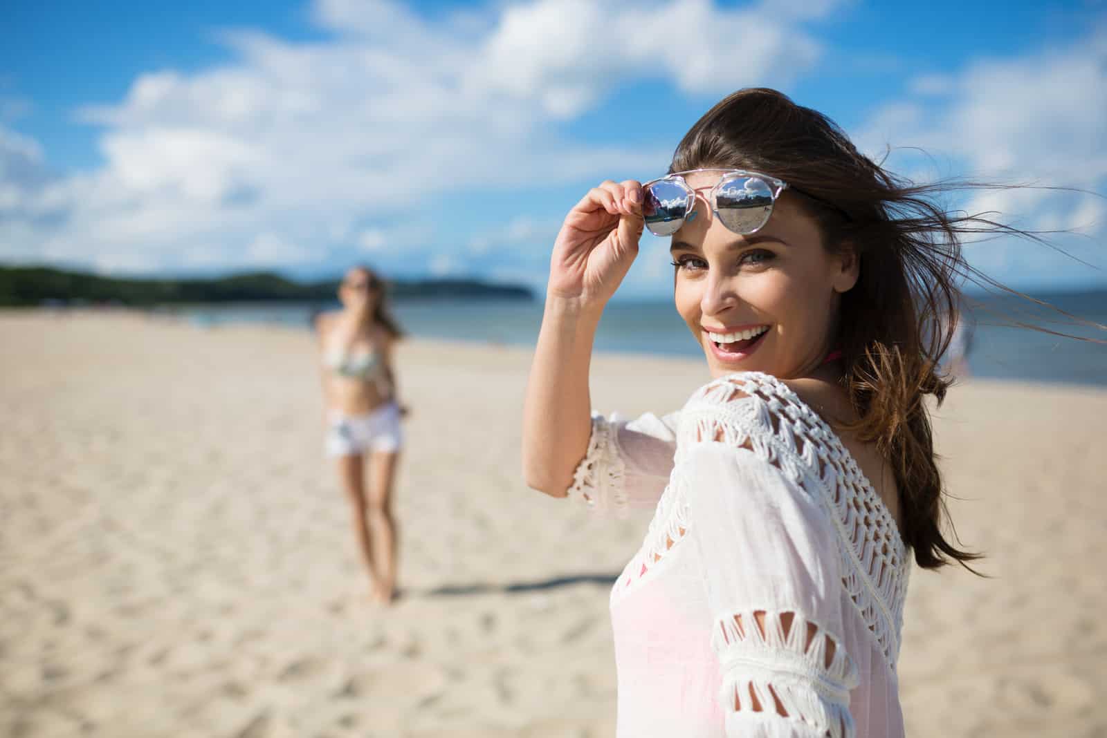 une femme avec des lunettes sur la tête rit