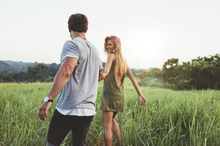 un homme et une femme traversent le champ