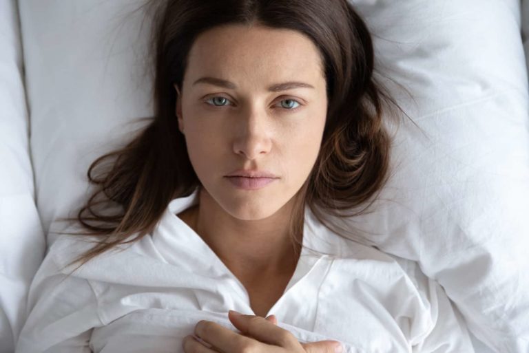 femme triste couchée dans son lit et penser