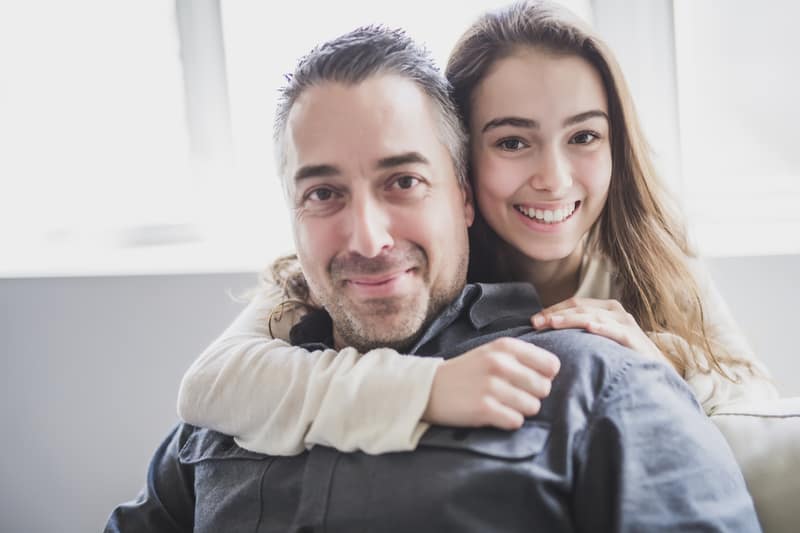 Fille adolescente assise sur la fenêtre avec le père
