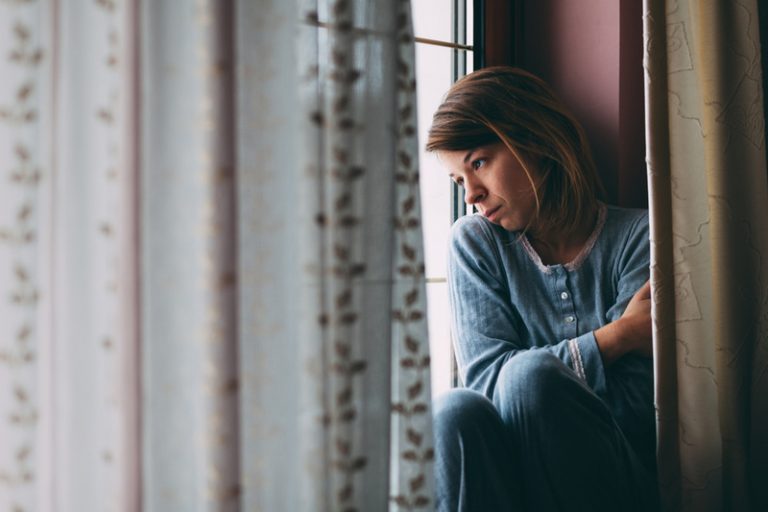 la femme regarde par la fenêtre