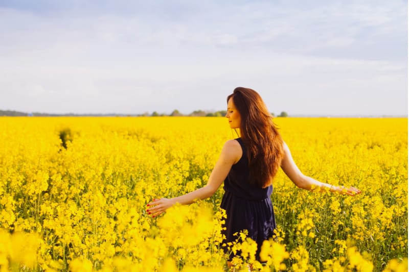 Jeune femme en robe sans manches profitant de la lumière du soleil