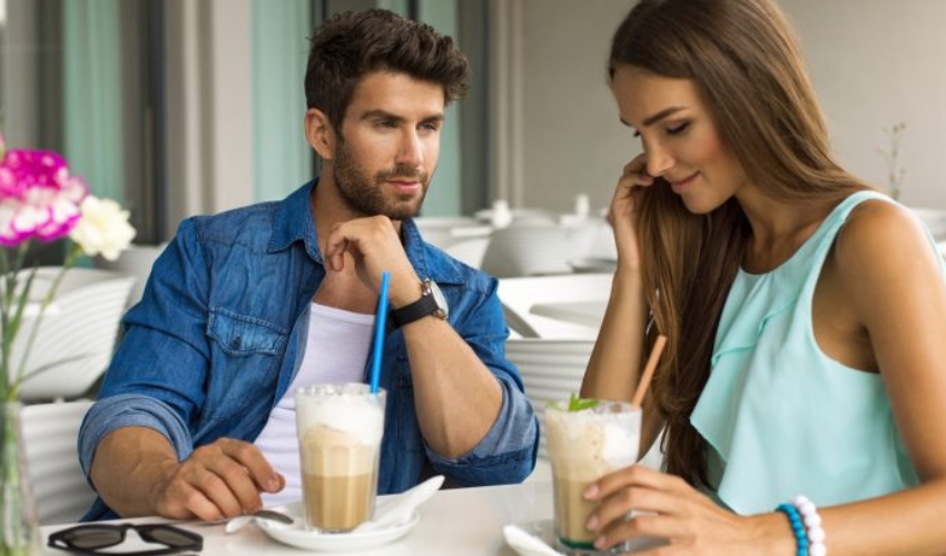 un homme et une femme sassoient et boivent du chocolat chaud