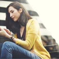 femme assise et bouton sur le téléphone