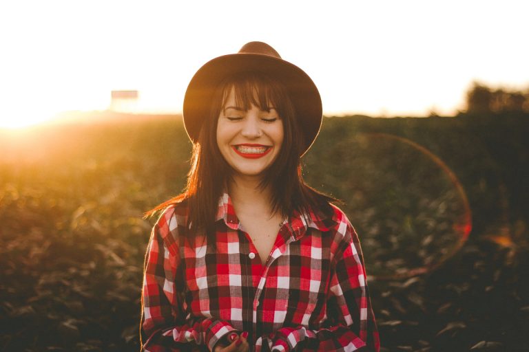femme souriante portant un chapeau