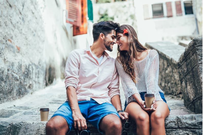 un homme et une femme sont assis amoureux sur le mur