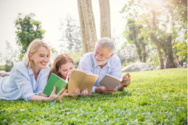heureux, famille, homme aîné, femme, et, petite fille, lecture