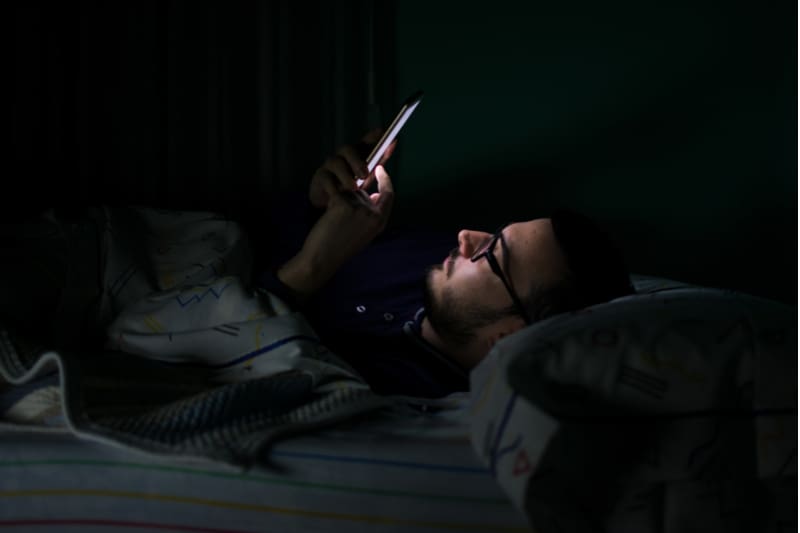 homme regardant son smartphone la nuit