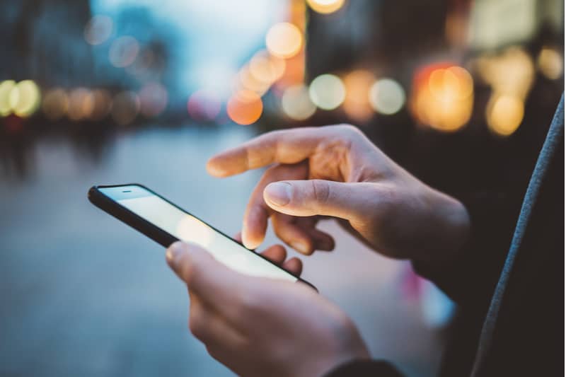 mage de mains mâles à laide de smartphone la nuit