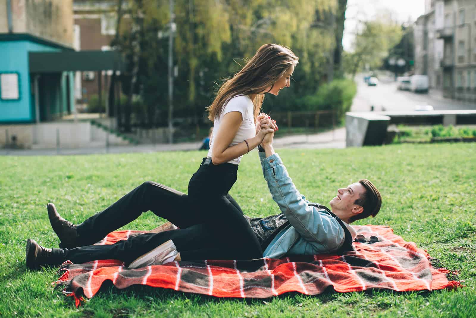 un homme et une femme s'allongent sur l'herbe et rient