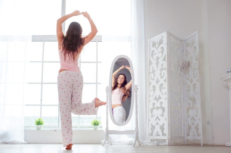 une femme dansant devant un miroir