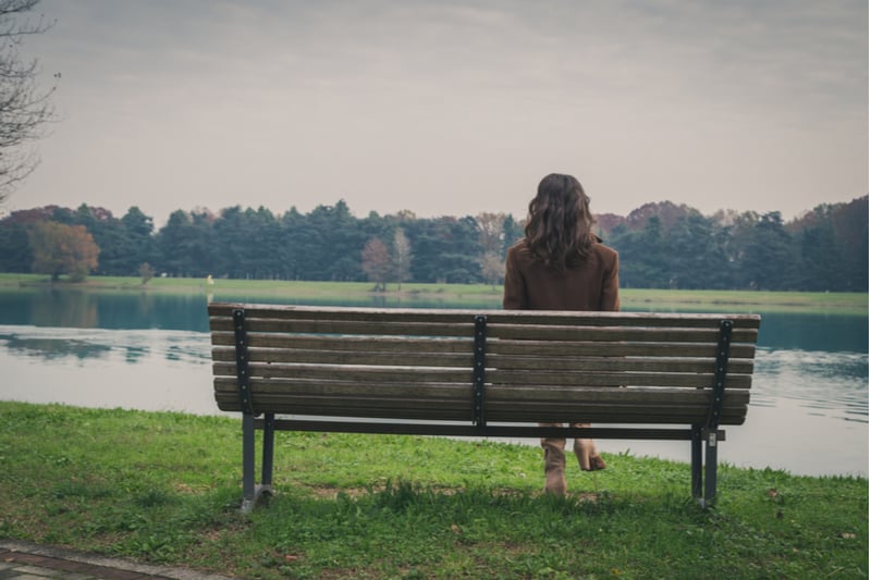 une femme triste assise sur un banc
