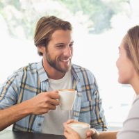 un homme et une femme s'assoient et boivent du café