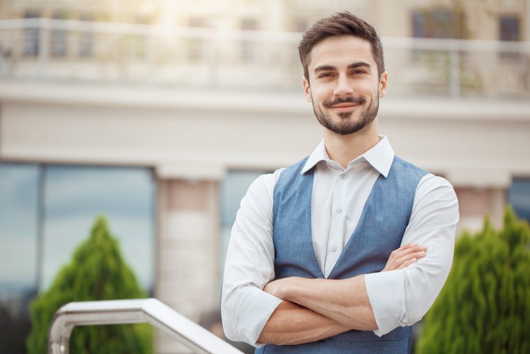 un homme en chemise et gilet se lève et rit