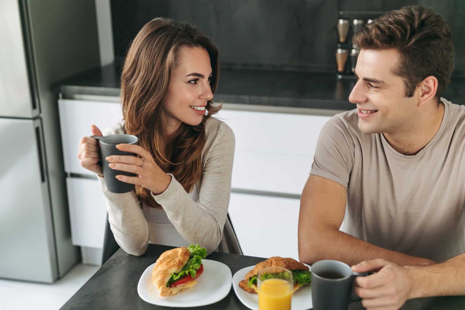 un homme et une femme prennent le petit déjeuner et parlent