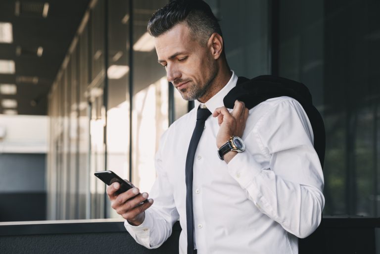 l'homme se lève et écrit au téléphone